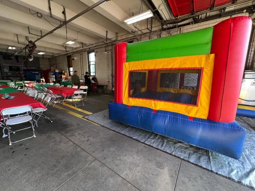 Bounce house set up indoors beside party seating