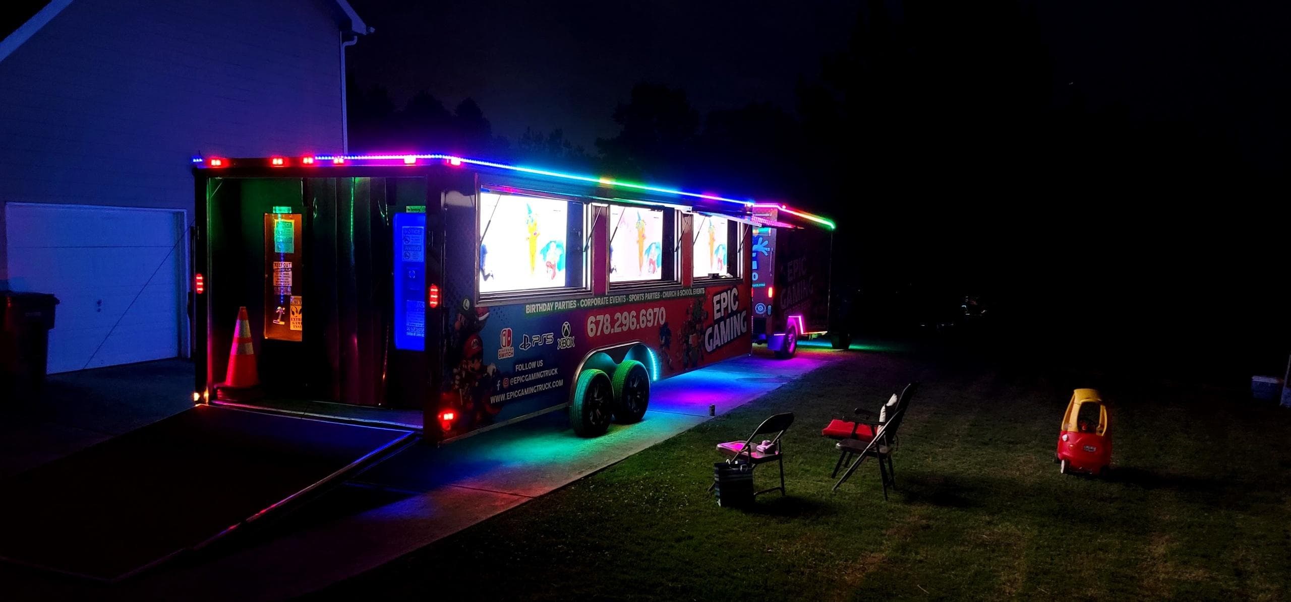 LED-lit gaming trailer parked outside for a nighttime event