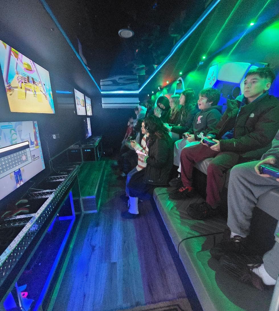 Children playing video games inside a gaming trailer